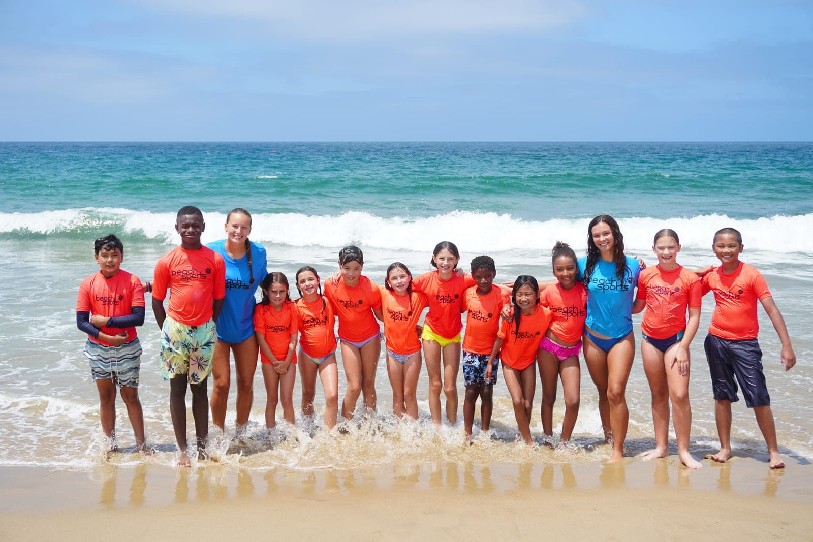 A group of BeachSports campers and coaches together on the beach
