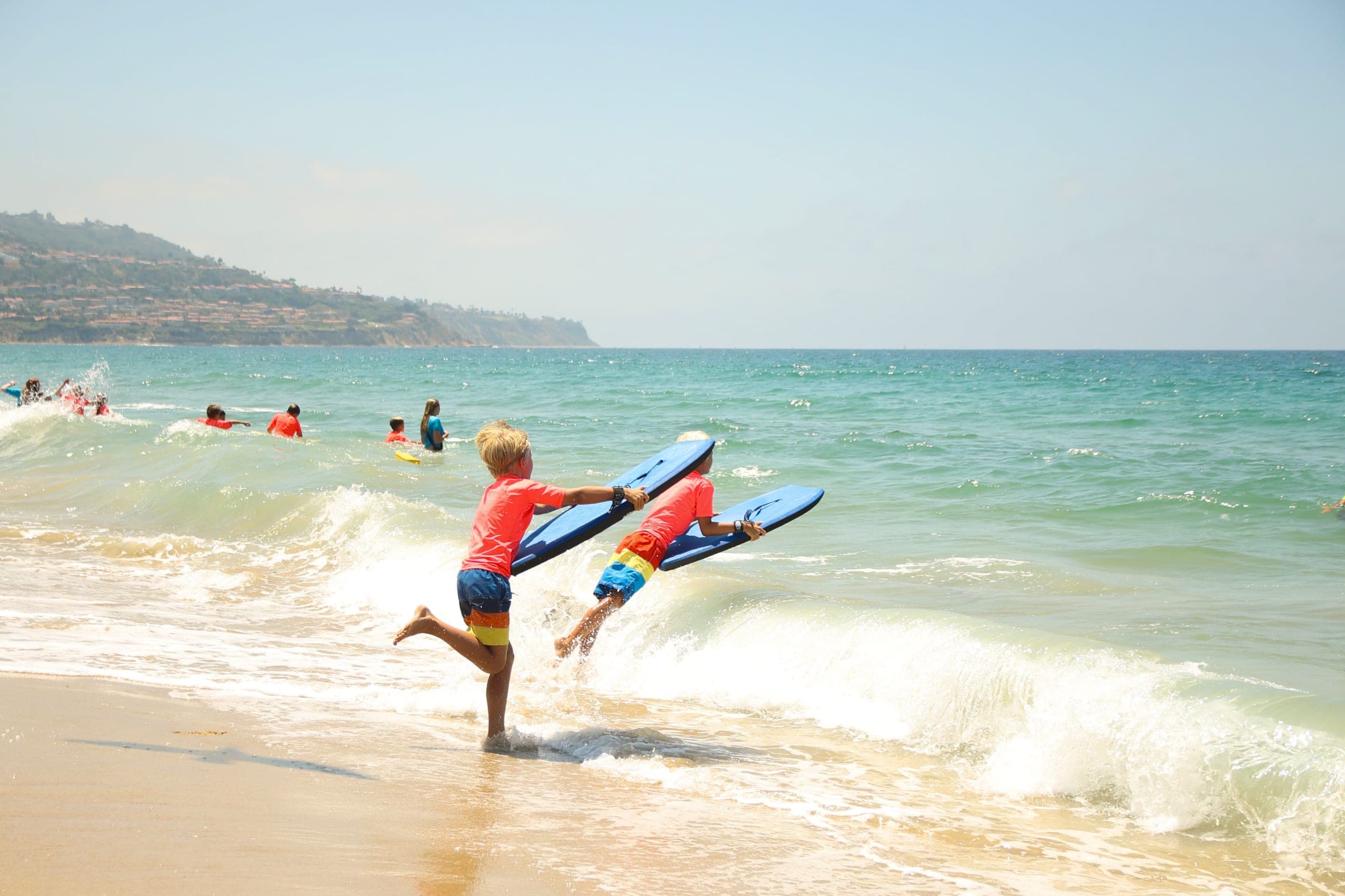 Kids splashing in the shallow water at beach camp