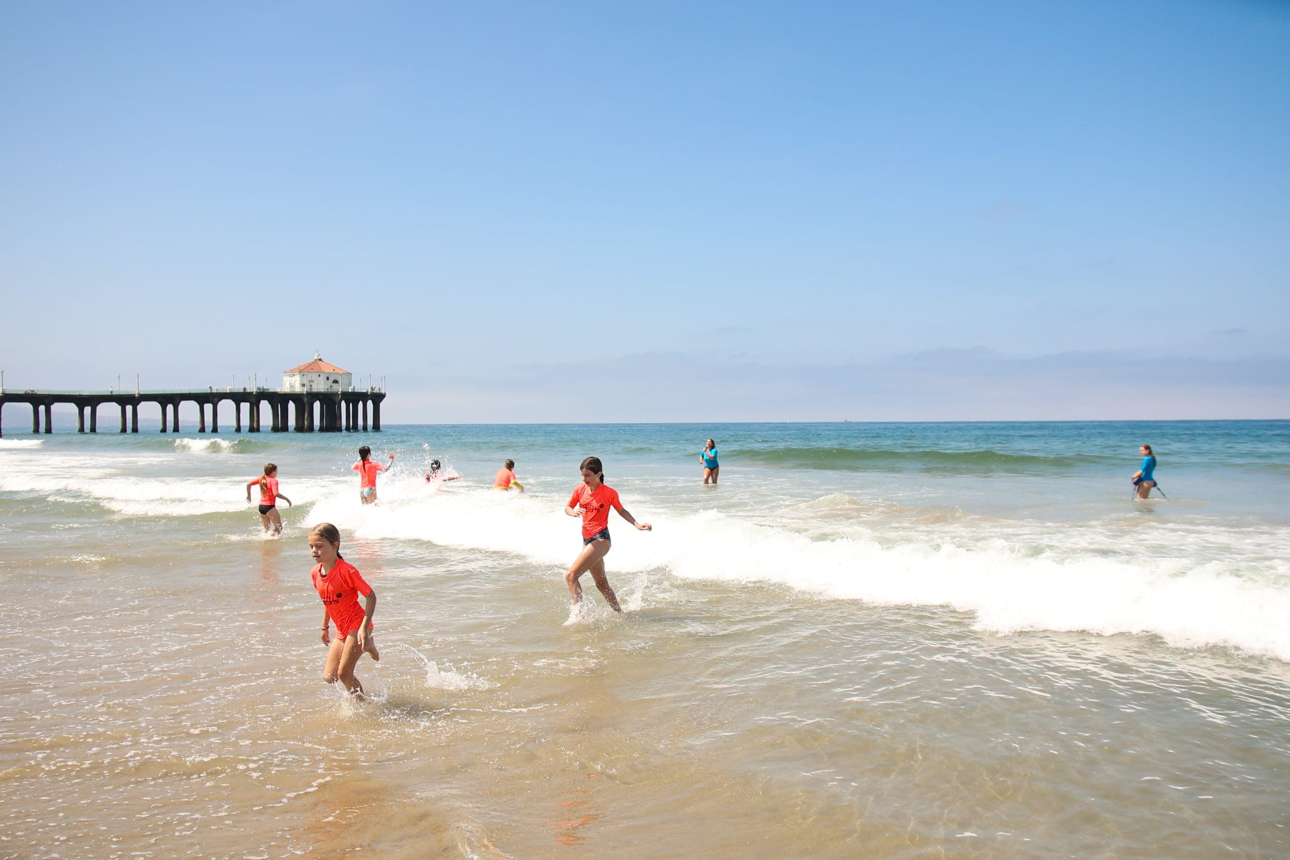 Ocean Program campers running into the surf together
