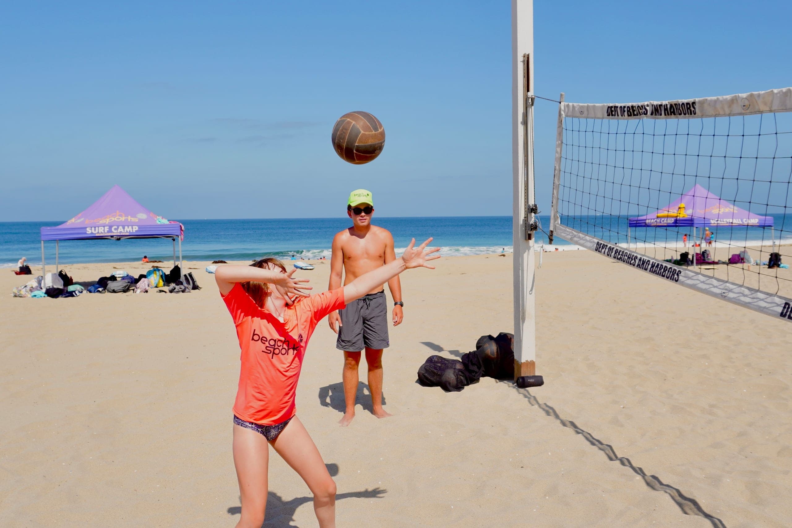 Coaches and campers running a volleyball drill together